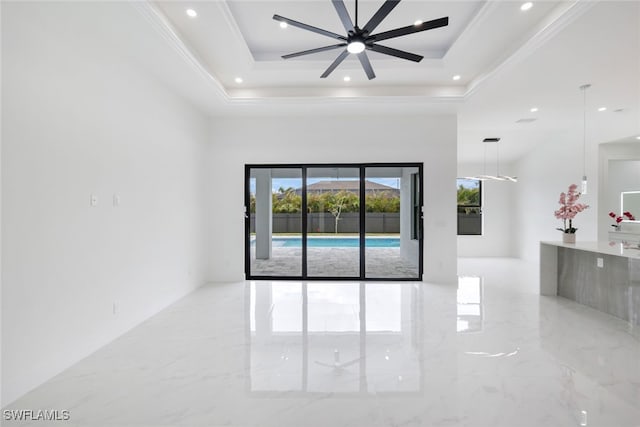 spare room featuring a tray ceiling, ceiling fan, and ornamental molding