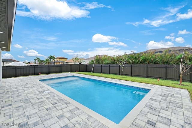 view of swimming pool featuring a yard and a patio area