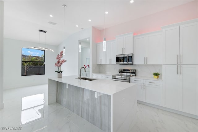 kitchen featuring white cabinetry, sink, stainless steel appliances, and decorative light fixtures