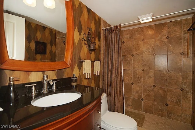 bathroom with tile patterned floors, vanity, toilet, and walk in shower