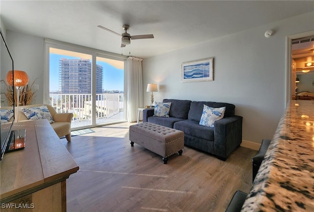 living room featuring ceiling fan and wood-type flooring