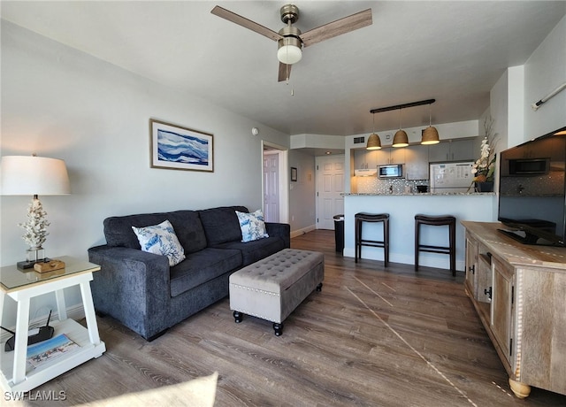 living room featuring dark hardwood / wood-style floors and ceiling fan