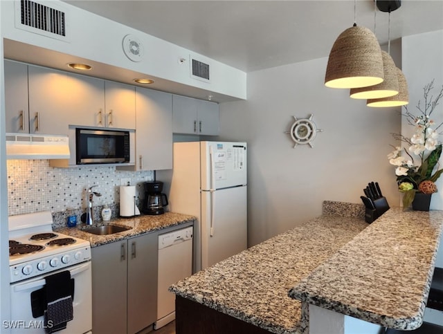 kitchen with sink, hanging light fixtures, kitchen peninsula, white appliances, and decorative backsplash