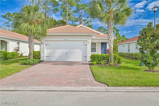 mediterranean / spanish home with a garage and a front lawn