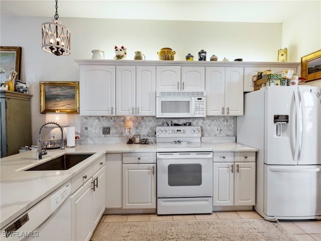 kitchen with white appliances, sink, an inviting chandelier, white cabinetry, and hanging light fixtures