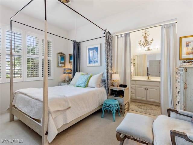 carpeted bedroom featuring ensuite bathroom and sink