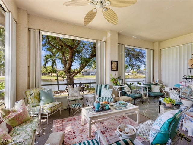 sunroom / solarium with ceiling fan and a water view