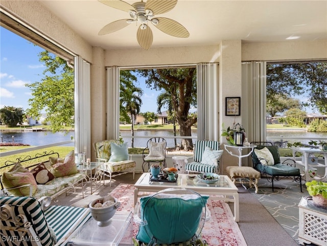 sunroom / solarium with ceiling fan and a water view