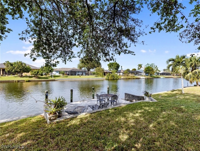 dock area with a lawn and a water view