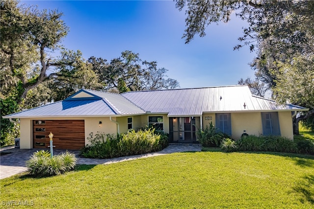 ranch-style home featuring a garage and a front lawn