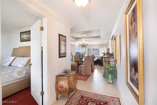 hallway featuring tile patterned flooring, a tray ceiling, an inviting chandelier, and crown molding