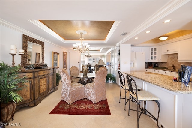 dining room with a raised ceiling, crown molding, light tile patterned flooring, and a chandelier