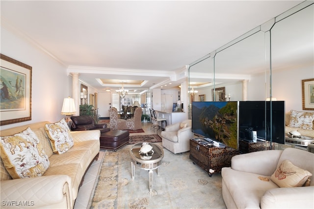 living room with decorative columns, crown molding, and a notable chandelier