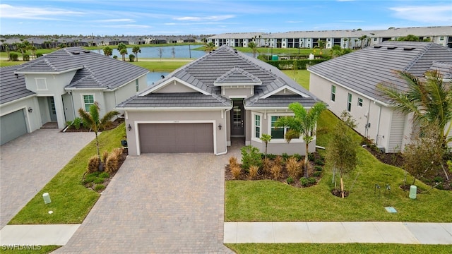 view of front of property featuring a front yard, a water view, and a garage