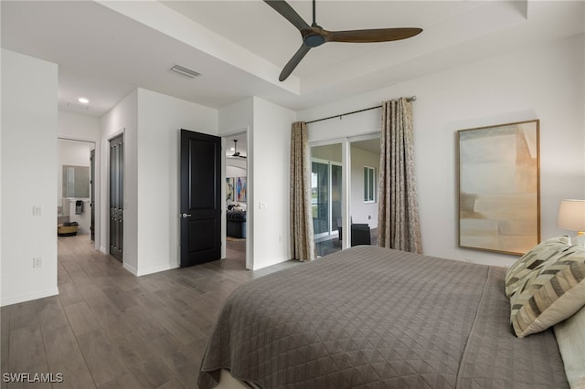 bedroom with a raised ceiling, access to exterior, ceiling fan, and dark hardwood / wood-style flooring