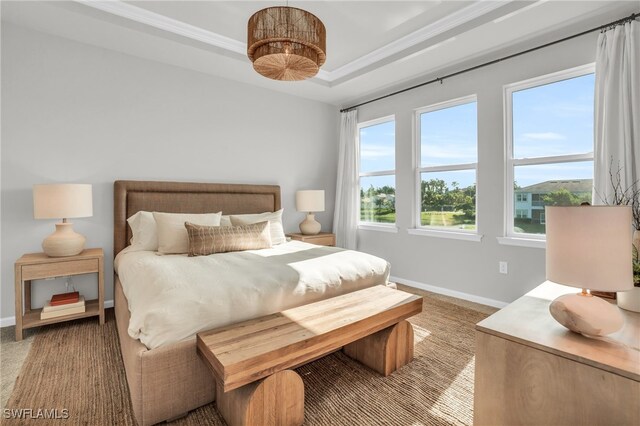 bedroom with carpet, a tray ceiling, and crown molding