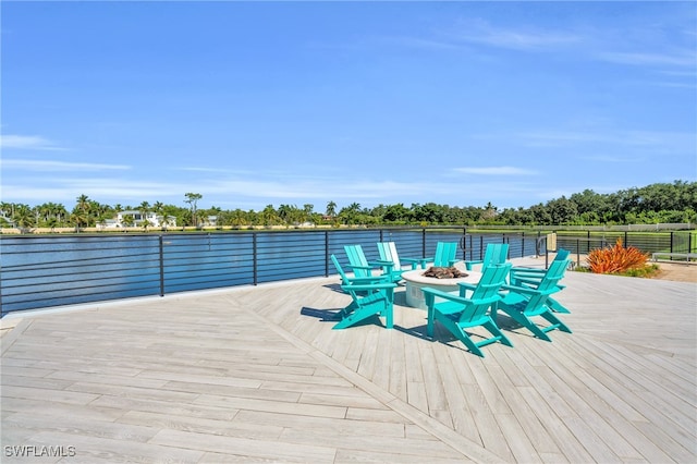 deck with a water view and a fire pit