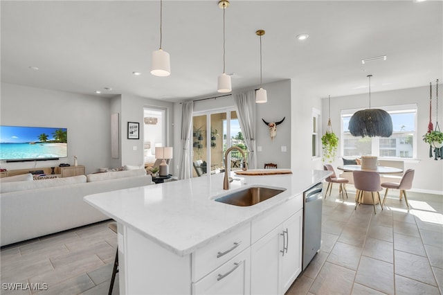 kitchen with white cabinetry, dishwasher, sink, an island with sink, and decorative light fixtures