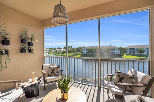 sunroom featuring a water view