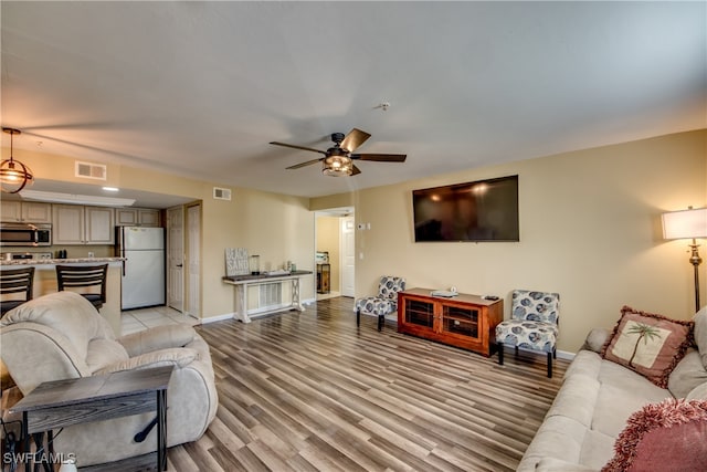 living room featuring ceiling fan and light wood-type flooring