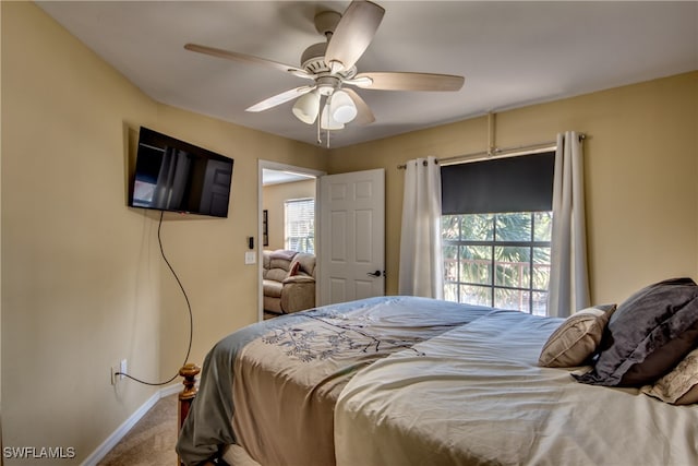 bedroom featuring ceiling fan, carpet floors, and multiple windows