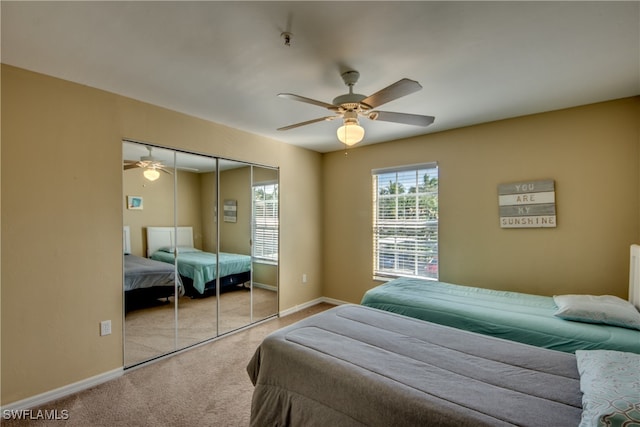 bedroom featuring ceiling fan, a closet, and light colored carpet