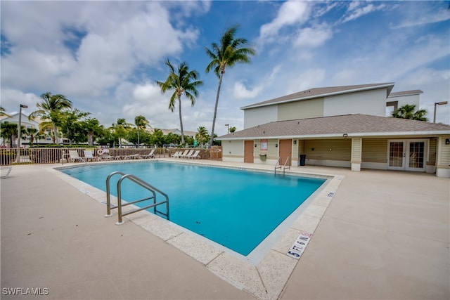 view of swimming pool with a patio and french doors