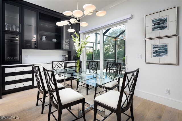 dining room with crown molding, light hardwood / wood-style floors, and a notable chandelier