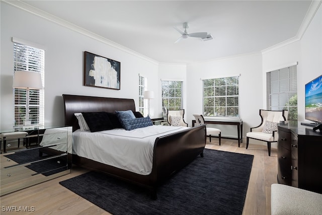 bedroom with light wood-type flooring, ceiling fan, and crown molding