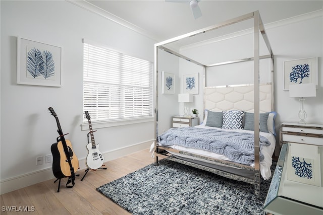 bedroom with hardwood / wood-style floors, ceiling fan, and crown molding