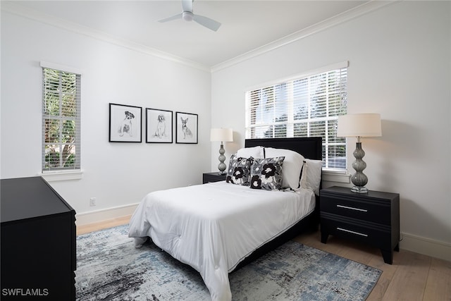 bedroom with hardwood / wood-style floors, ceiling fan, ornamental molding, and multiple windows