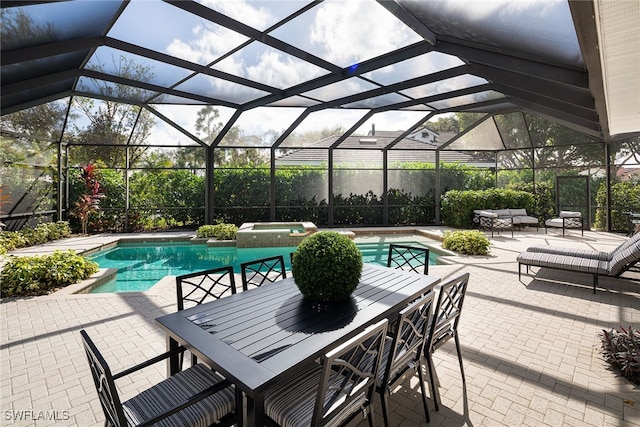 view of pool with glass enclosure, a patio area, and an in ground hot tub