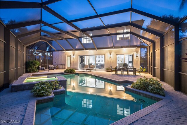 view of swimming pool featuring a lanai, an in ground hot tub, and a patio