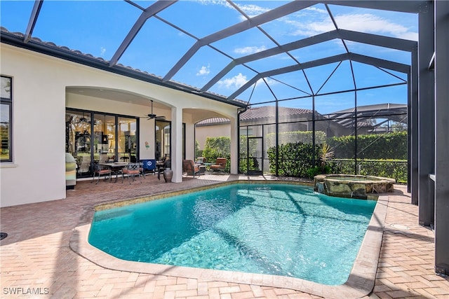 view of swimming pool featuring an in ground hot tub, ceiling fan, a patio, and glass enclosure