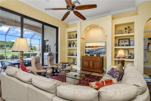 living room with crown molding, ceiling fan, and built in shelves