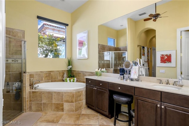 bathroom with plus walk in shower, a healthy amount of sunlight, vanity, and tile patterned floors