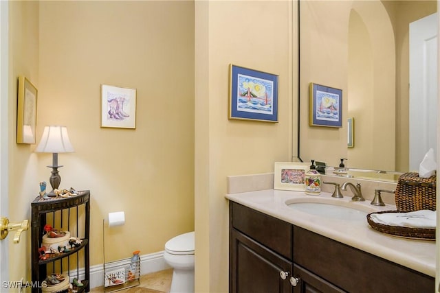 bathroom featuring tile patterned flooring, vanity, and toilet