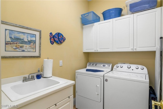 laundry room with independent washer and dryer, cabinets, and sink