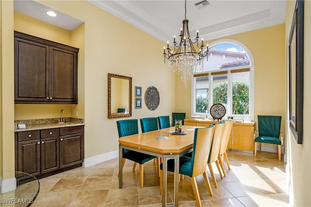 dining space featuring sink, crown molding, a notable chandelier, and light tile patterned floors