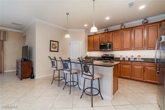 kitchen with hanging light fixtures, crown molding, a center island with sink, and stainless steel appliances