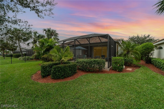 yard at dusk featuring glass enclosure