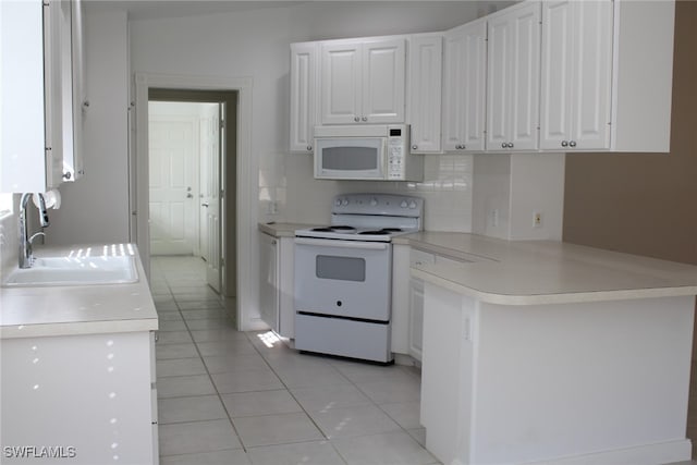 kitchen featuring white cabinets, light tile patterned flooring, and white appliances