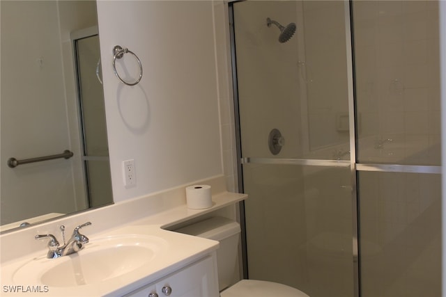 bathroom featuring toilet, vanity, and walk in shower