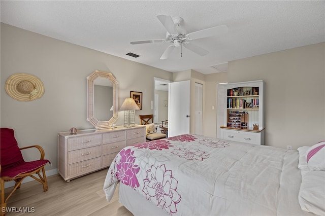 bedroom featuring a textured ceiling, light wood-type flooring, a closet, and ceiling fan