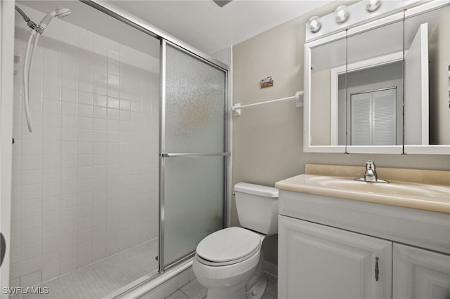 bathroom featuring tile patterned flooring, vanity, toilet, and walk in shower