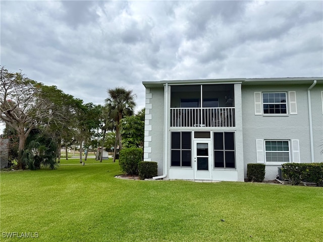 rear view of property featuring a lawn