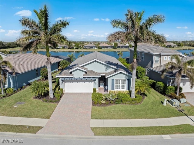 view of front of home with a water view, a garage, and a front lawn