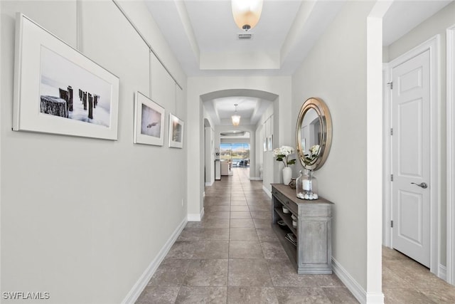 corridor featuring a tray ceiling