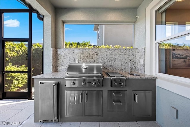 view of patio / terrace featuring an outdoor kitchen, sink, and grilling area