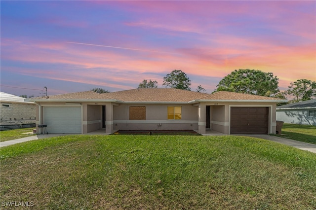 ranch-style house with a garage and a yard